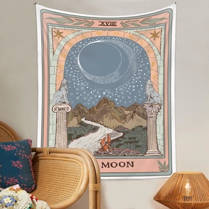 Detail view of Bohemian Moon tarot tapestry hanging over a rattan chair in a cozy room