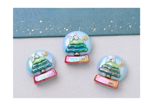 Detailed view of Christmas resin charms with snowman and tree shapes for DIY crafts