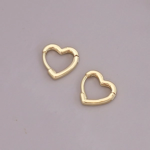 Macro shot of polished 18K gold heart-shaped metal earrings with minimalist geometric design