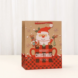 Christmas kraft paper gift bag with Santa Claus print and red handles on white background