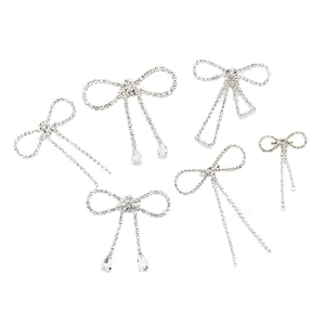 Elegant silver bow brooch set with sparkling rhinestones and teardrop pendants