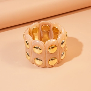 Macro detail of acrylic stretch bracelet with marble texture and gold metal studs