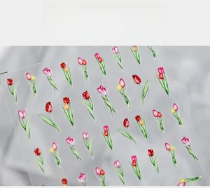 Macro detail of tulip flower nail art stickers with vibrant red and yellow floral patterns
