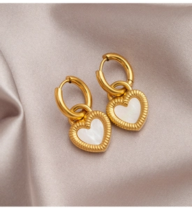 Detail of gold heart earrings with white mother of pearl inlay on silk background