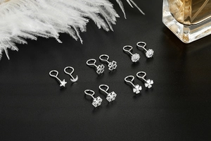 Detailed set of S999 sterling silver stud earrings in star, moon and floral shapes