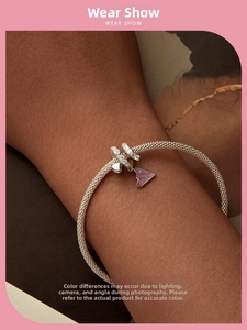 Silver woven mesh bracelet with pink triangle enamel pendant and heart charm on wrist