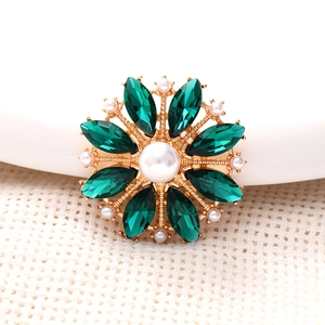 Macro shot of zinc alloy flower accessory with green marquise stones and white pearls