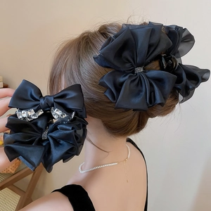 Elegante pinza per capelli con grande fiocco nero a strati e dettaglio di diamanti