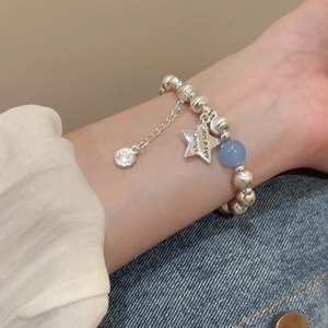 Detail of beaded bracelet with Stay Bright star charm and blue bead on wrist