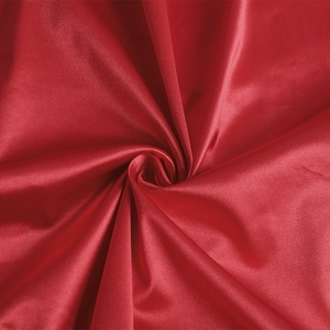 Close-up of red silk satin fabric texture showing smooth glossy finish and soft folds