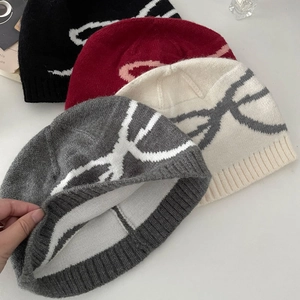 Close-up showing the soft knitted inner lining of bow-patterned winter beanies in four colors