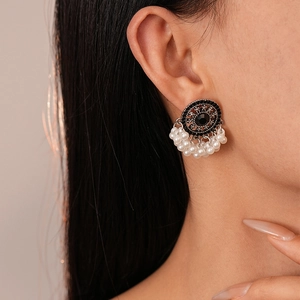 Detail of vintage round earrings with black rhinestones and white pearl tassels on model