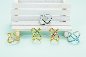 Detail of adjustable X-shaped rings with colorful zircon inlays in gold and silver
