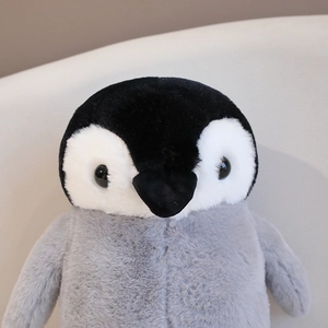 Macro view of cute penguin plush toy focusing on its soft grey and black head