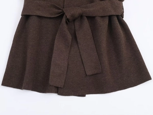 Dettaglio giacca in maglia marrone scuro con cintura a coulisse morbida e trama liscia
