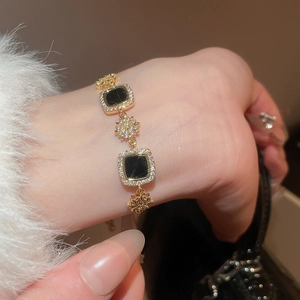 Détail d'un bracelet plaqué or 18 carats avec finition carrée noire et pierres de zircon