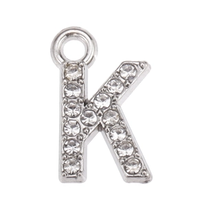 Macro shot of silver letter K pendant with sparkling white rhinestones for DIY jewelry