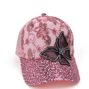 Close-up of pink mesh baseball cap with sequined butterfly, floral embroidery and rhinestones