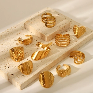Minimalist gold geometric irregular rings collection on stone platform