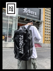 Outdoor shot showing a large black Oxford travel backpack with TUSENTE branding on the side