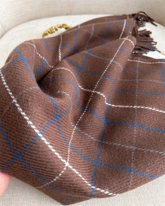 Close-up of brown plaid scarf with blue and white lines, soft texture and fringe details