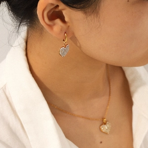 Luxury stainless steel heart jewelry set with necklace and earrings worn by a model