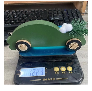 Detailed view of dark green wooden car ornament on a scale showing 122.3g weight