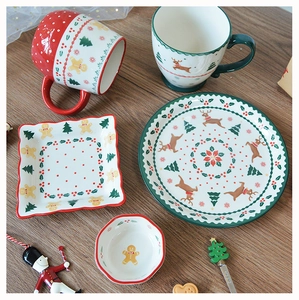 Christmas ceramic tableware set with gingerbread man and reindeer patterns on wooden table