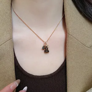 Tiger eye stone double gourd pendant necklace with gold chain and diamond accents on model
