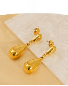 Detailed macro view of gold hollow teardrop earrings made of polished stainless steel