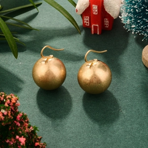 Boucles d'oreilles boules dorées de style français avec fini mat sur fond vert festif