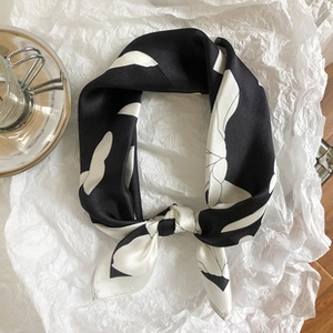 Macro detail of silk scarf with black and white abstract leaf pattern and smooth texture