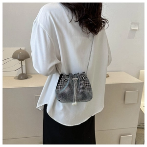 Detail of black rhinestone bucket bag with silver chain and pearl drawstring charms