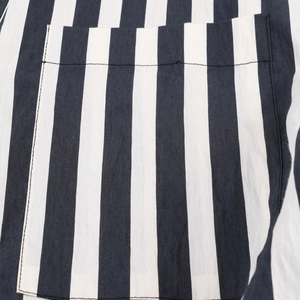 Close-up detail of black and white vertical striped shirt pocket with woven texture
