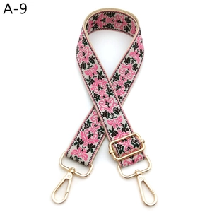 Macro shot of colorful floral embroidery strap with golden metal lobster clasps