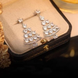 Sparkling silver Christmas tree earrings with inlaid zircons on a luxury jewelry box