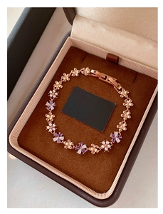 Close-up of rose gold floral pearl bracelet with purple zircon inlay in jewelry box