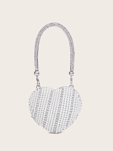 Macro shot of heart-shaped evening bag with white faux pearls and sparkling rhinestones