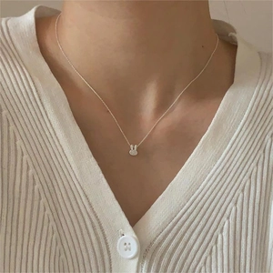 Close-up of minimalist 925 sterling silver rabbit pendant necklace on a model