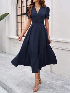 Close-up of elegant V-neck and pleated waist detail on the dark blue short sleeve dress