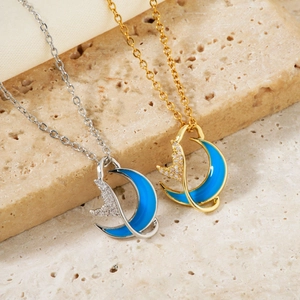 Elegant gold and silver necklaces with blue moon and fishtail pendants on a stone base
