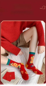 Detail of red festive cotton socks with dragon motifs in a cozy home setting