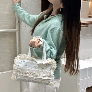 Détail du sac cabas floral avec bordure en dentelle blanche et étiquette en tissu