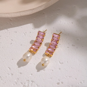 Dettaglio di orecchini placcati oro 18K con zircone rosa e perle bianche a goccia