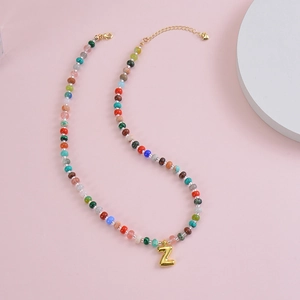 Detail of colorful beaded necklace featuring a 3D gold bubble letter Z pendant
