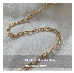 Detail of adjustable golden metal chain shoulder strap with lobster clasp for handbag