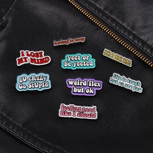 Detailed view of colorful letter enamel pins attached to a black leather jacket