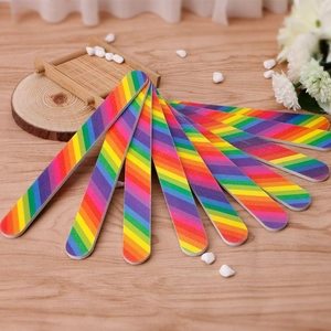 Rainbow striped nail files for professional manicures displayed on a wooden surface
