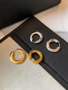 Detail of gold and silver chunky hoop earrings with zircon stones on a jewelry box