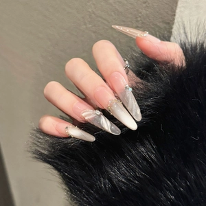 Cat-eye press-on nails in nude pink with pearls and rhinestones on long pointed tips